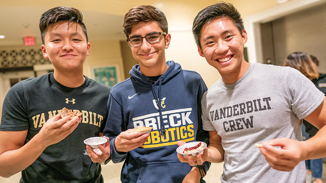 From left, first-years Steven Yang, Samuel Leville and Qi Yang Wong sample the pies offered during a weekly StamSweets event.