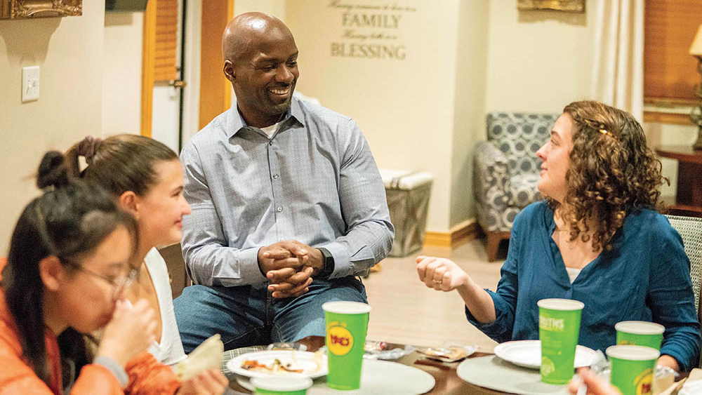 Noble (center) visits with Clara Leonard (right), a junior resident adviser in Stambaugh House, and first-years Catherine Crawford and Lauren Cheng during a dinner in the faculty residence.