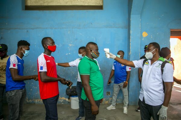 Health ministry workers check the temperature of mask-wearing fans prior to the start of a soccer match in Port-au-Prince, Haiti, on March 25, 2021.