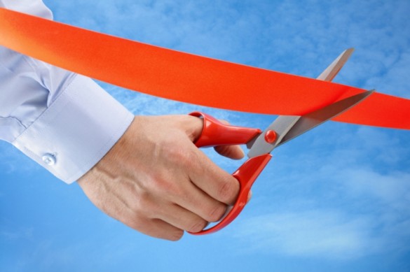 concept of scissors cutting red ribbon