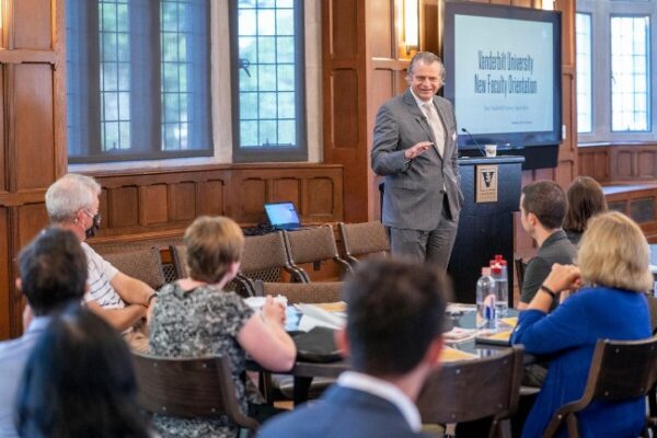 photograph of Chancellor Daniel Diermeier speaking to new faculty seated at round table 