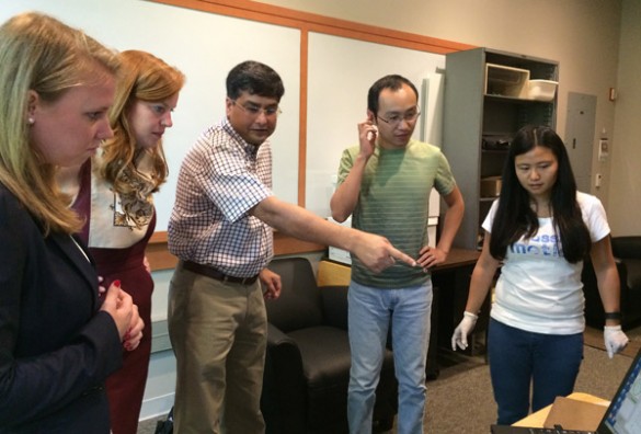 Professor of Mechanical Engineering Nilanjan Sarkar (center), accompanied by Ph.D. students Dayi Bian (second from right) and Jian Fan (far right), shows Kayla McMurry (far left) and Mackensie Burt (second from left) from Sen. Lamar Alexander's staff the simulator that he developed with researchers at the Vanderbilt Kennedy Center to help teenagers with autism learn to drive. (Vanderbilt University)