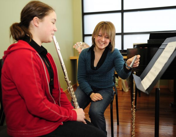 A Blair student teaches flute to a 7th grader at W.O. Smith Community Music School.