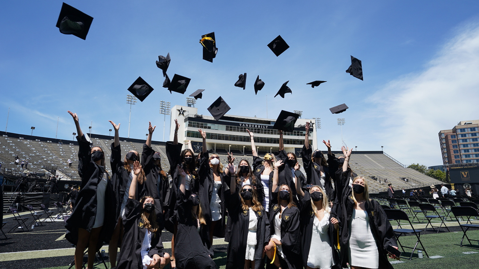 Students throwing graduation caps in Vanderbilt Stadium for Commencement 2021