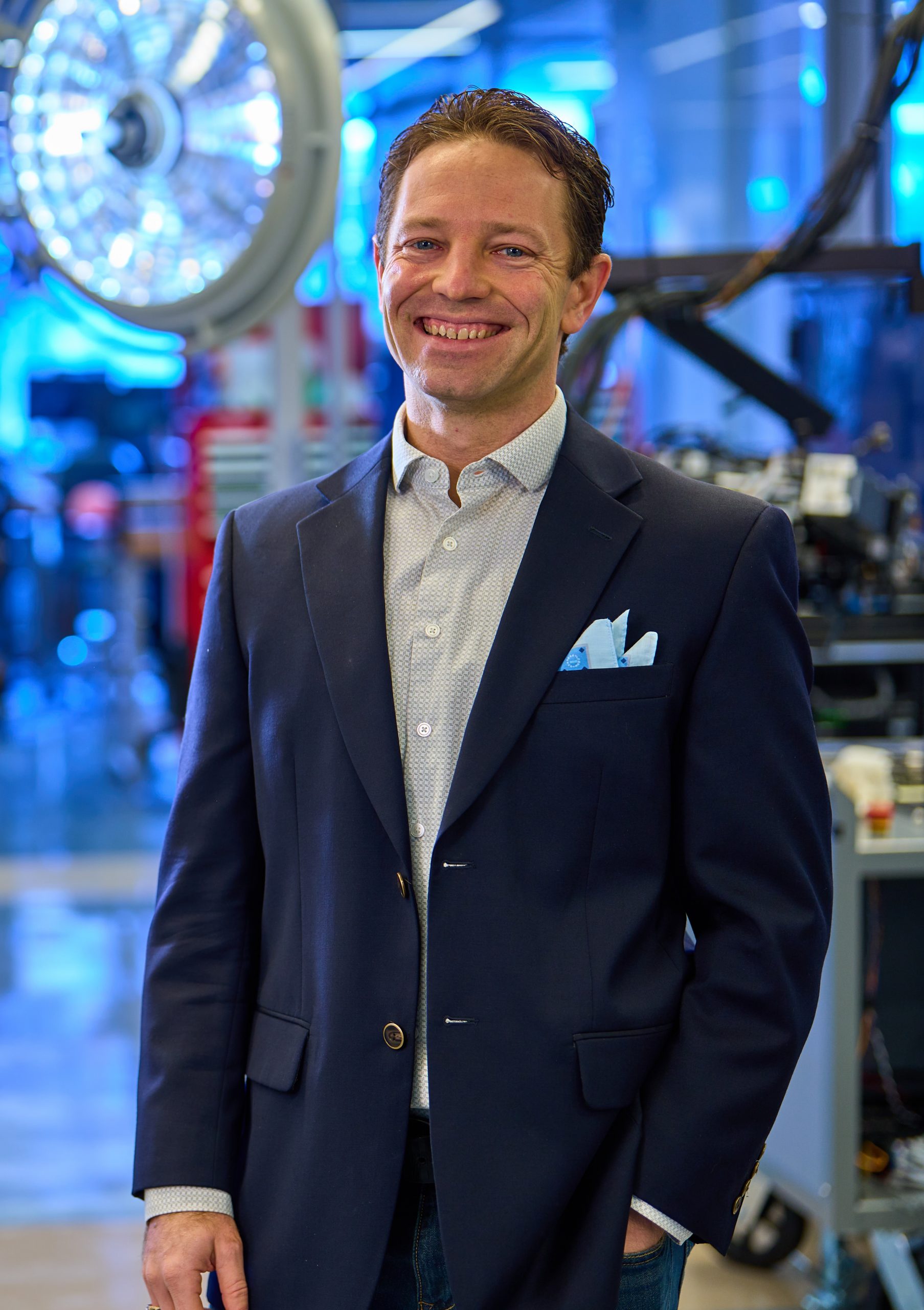A man standing in front of a blue-lit lab