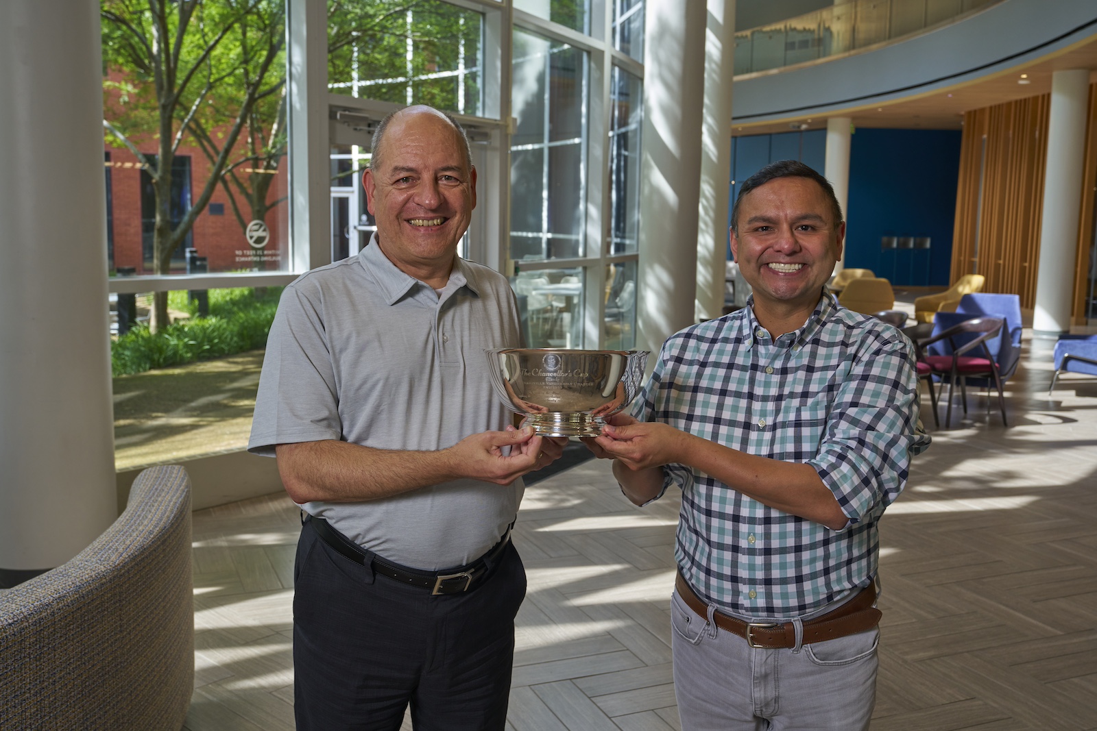 Professors Michael Lapre and Gilbert Gonzales with the Chancellors Cup