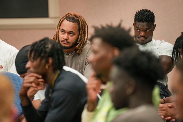 Several seated students listening intently to a debate.