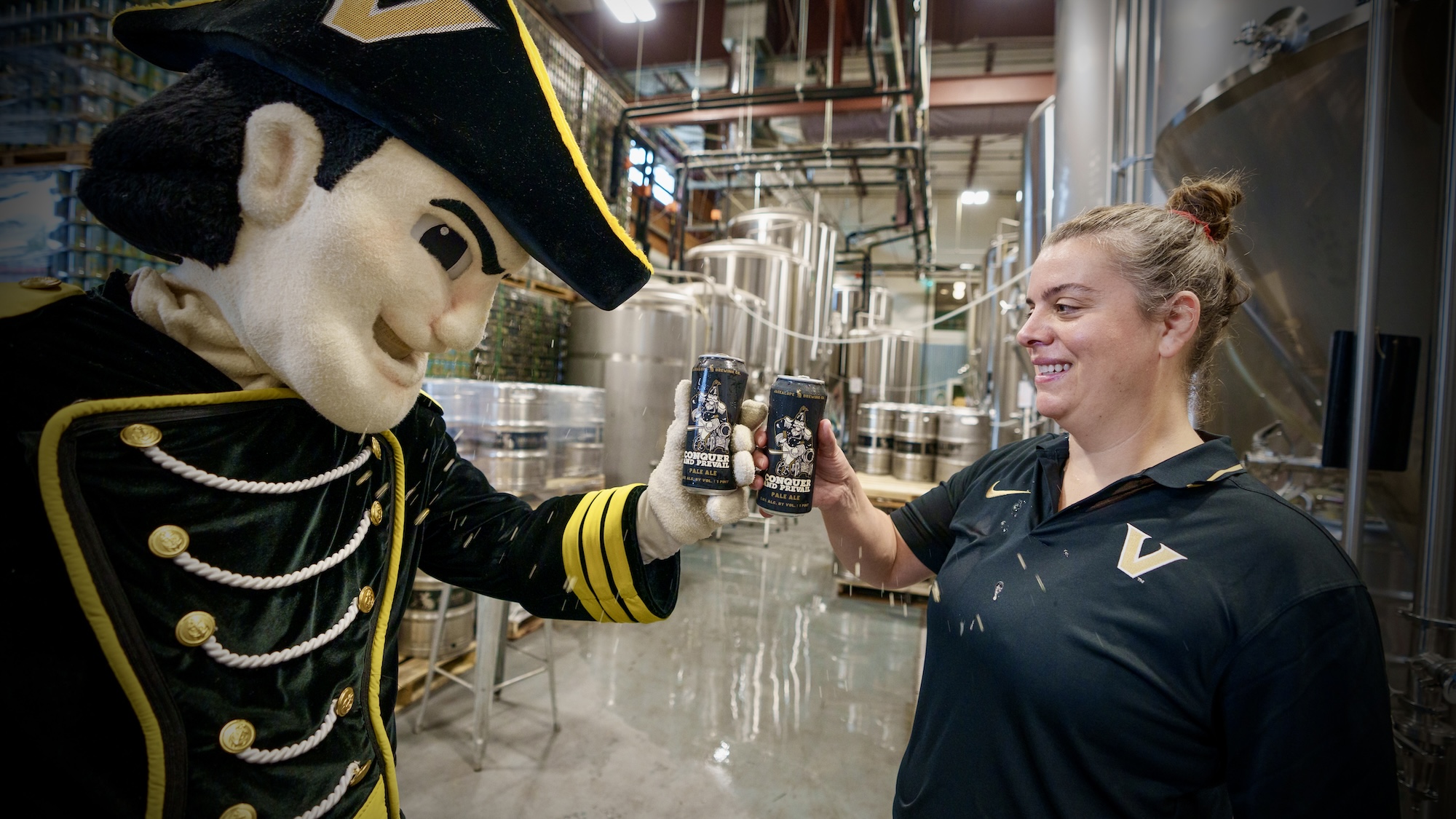 Mr. C and Bailey Spaulding toast with cans of Conquer and Prevail Ale.