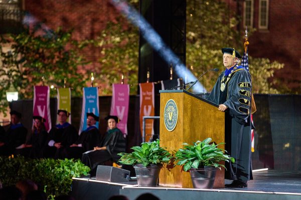 Chancellor Daniel Diermeier speaking from a podium on a stage.