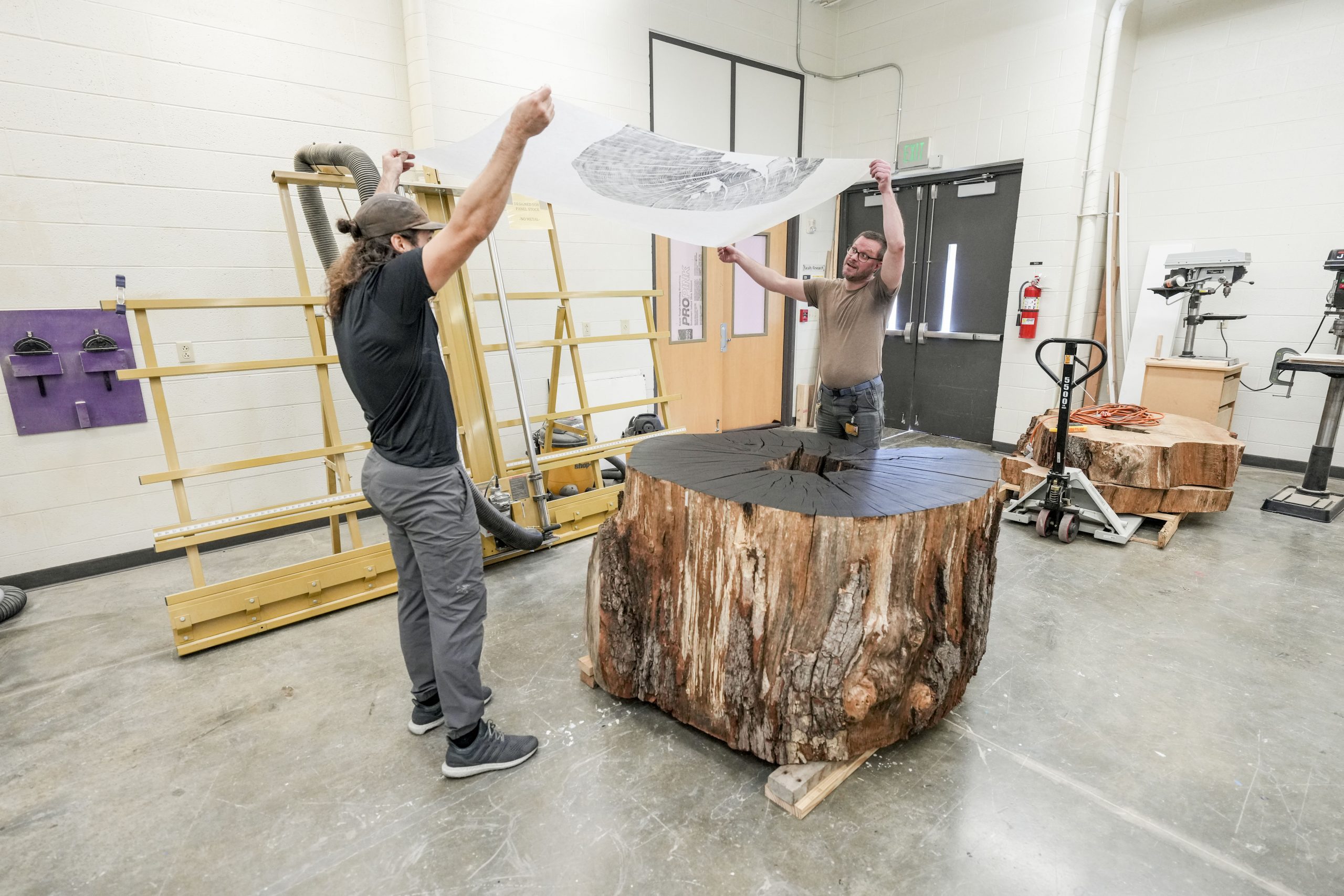 Art students watch as Artist Marko Barakoski makes tree prints at  Ingram Fine Arts studio using the wood from the Bicentennial Oak that fell on campus in 2022.