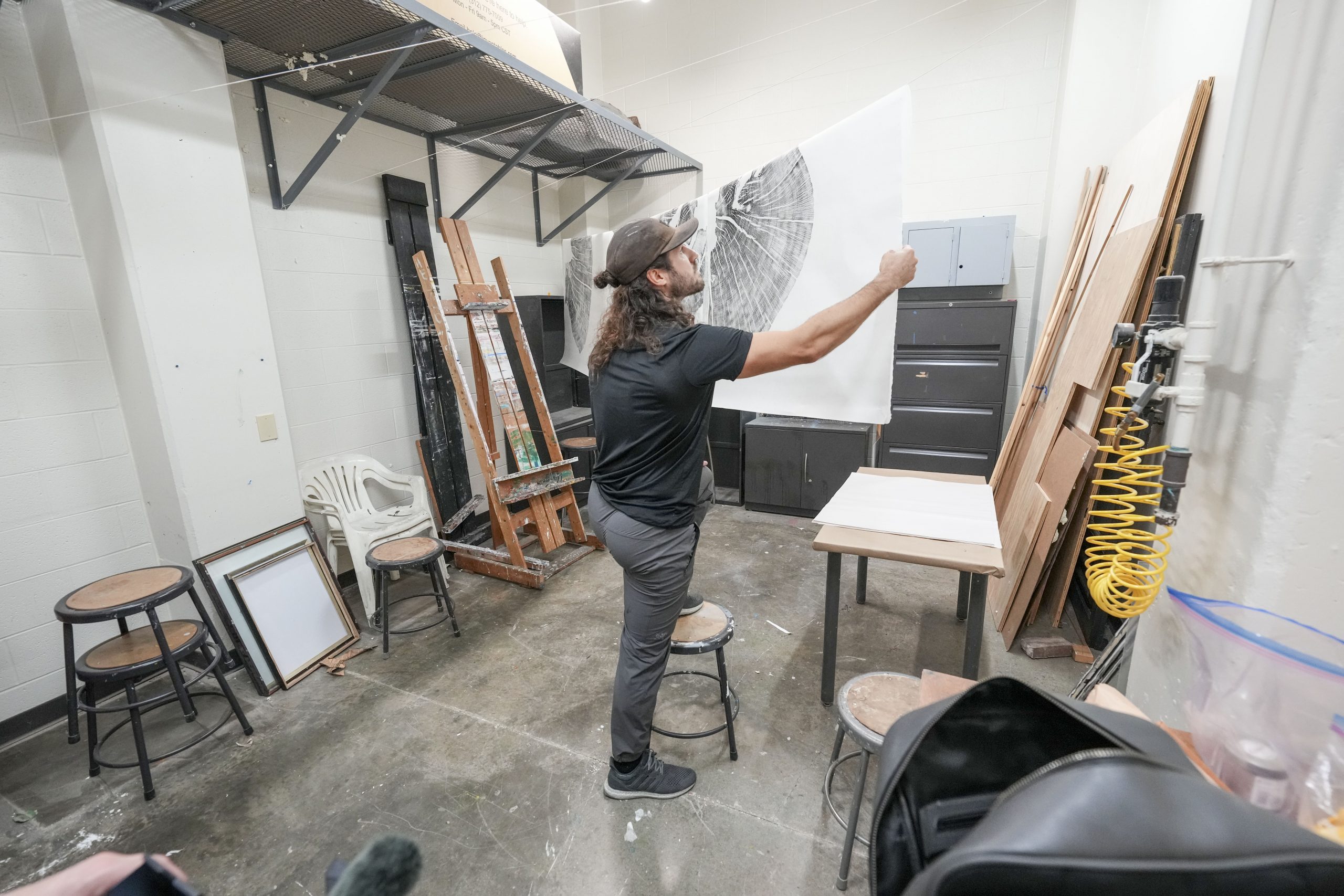 Art students watch as Artist Marko Barakoski makes tree prints at  Ingram Fine Arts studio using the wood from the Bicentennial Oak that fell on campus in 2022.