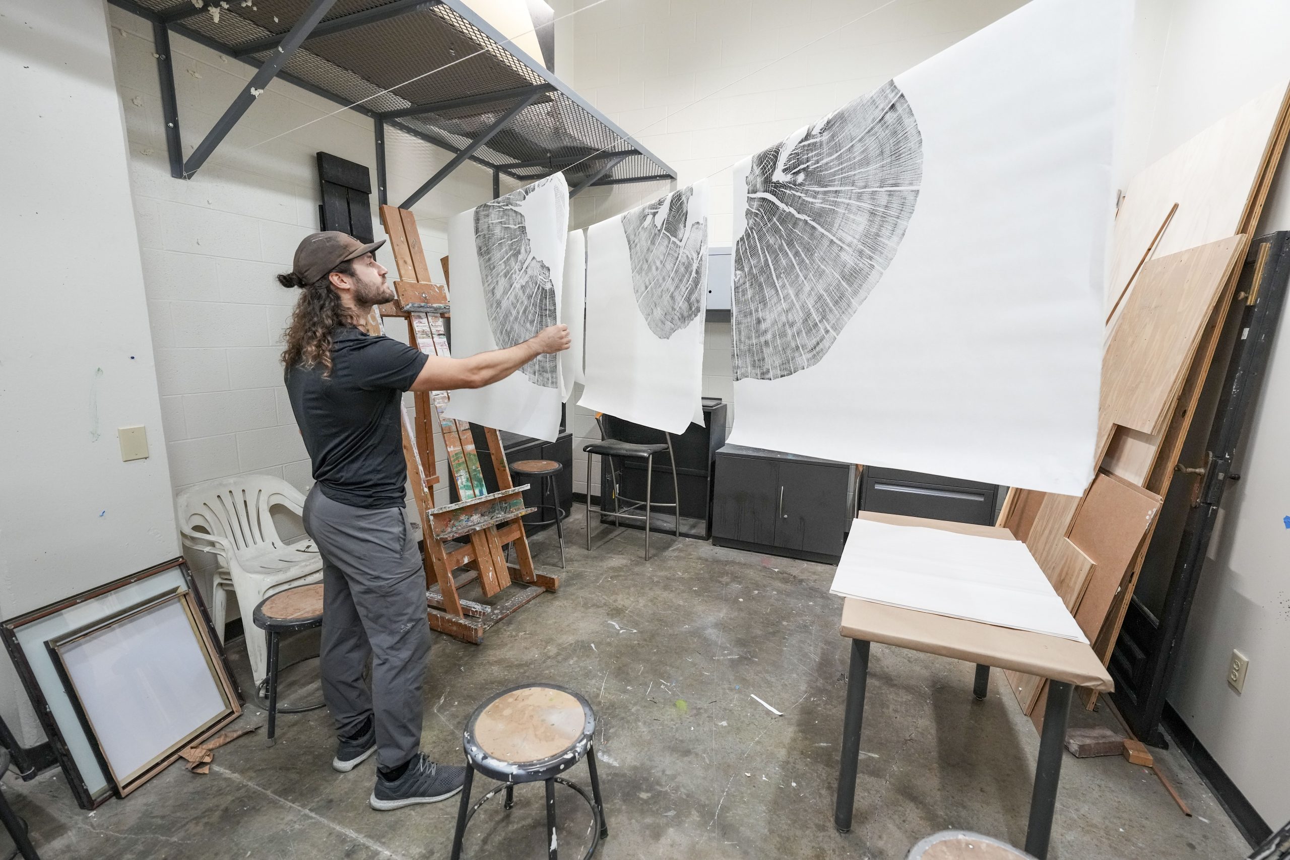 Art students watch as Artist Marko Barakoski makes tree prints at  Ingram Fine Arts studio using the wood from the Bicentennial Oak that fell on campus in 2022.