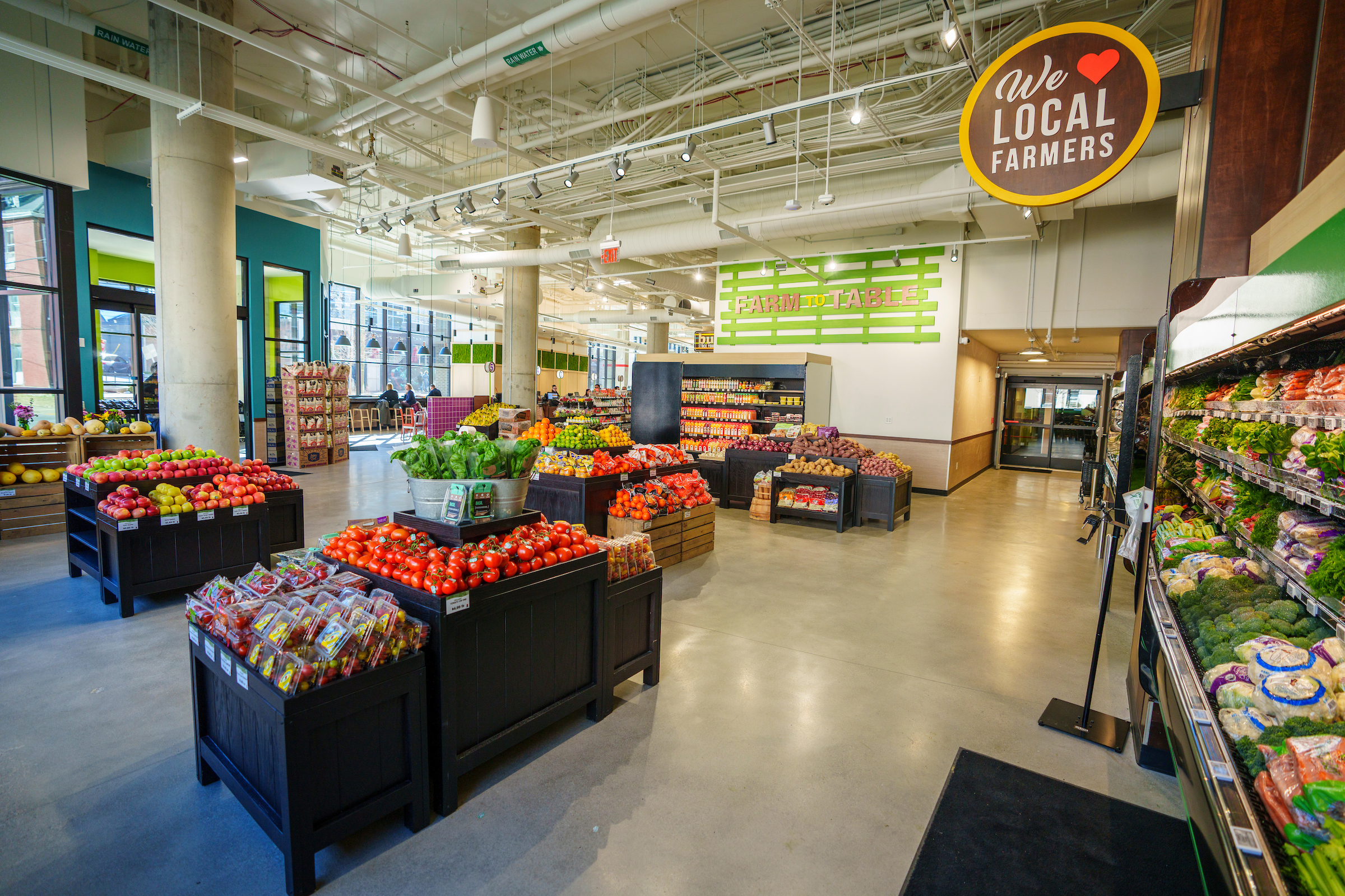 Lobby of a grocery store with bins of produce.