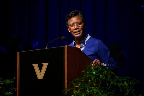 A woman in a blue suit speaking at a podium