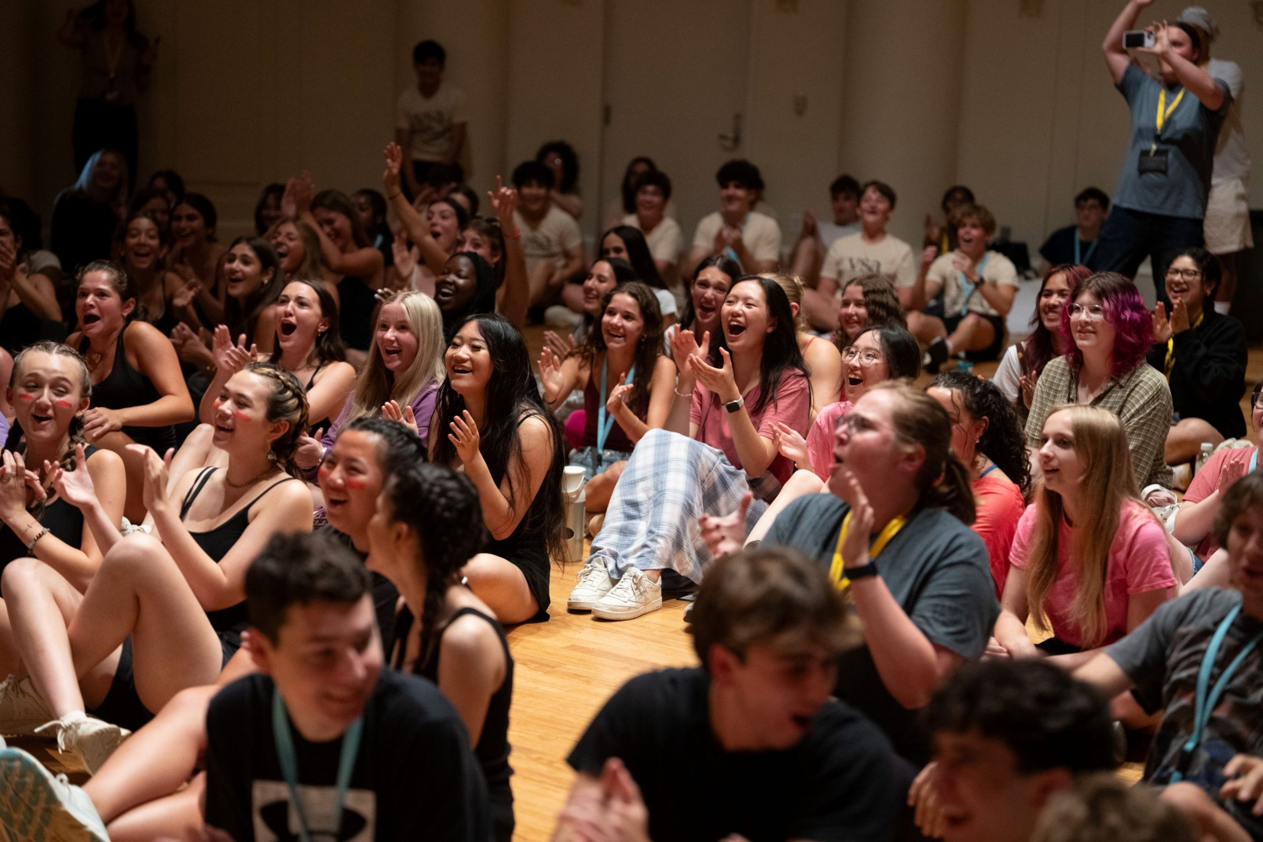 Two young girls give a peace sign and thumbs up