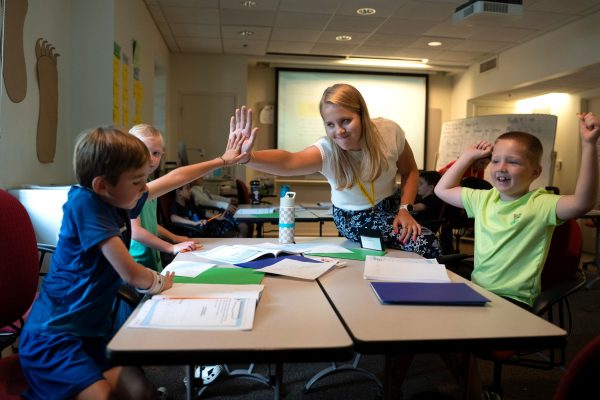 Teacher high fives a student inside classroom