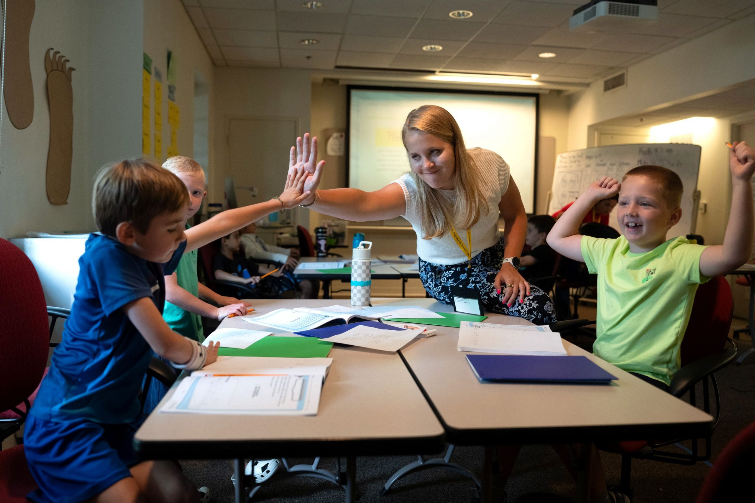 Teacher high fives a student inside classroom