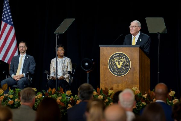 A man standing a podium speaking to an audience