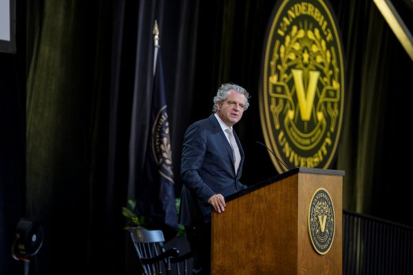 A man standing a podium speaking to an audience