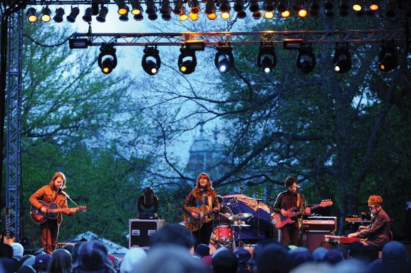 A band playing for the annual Rites of Spring weekend with campus buildings in the background