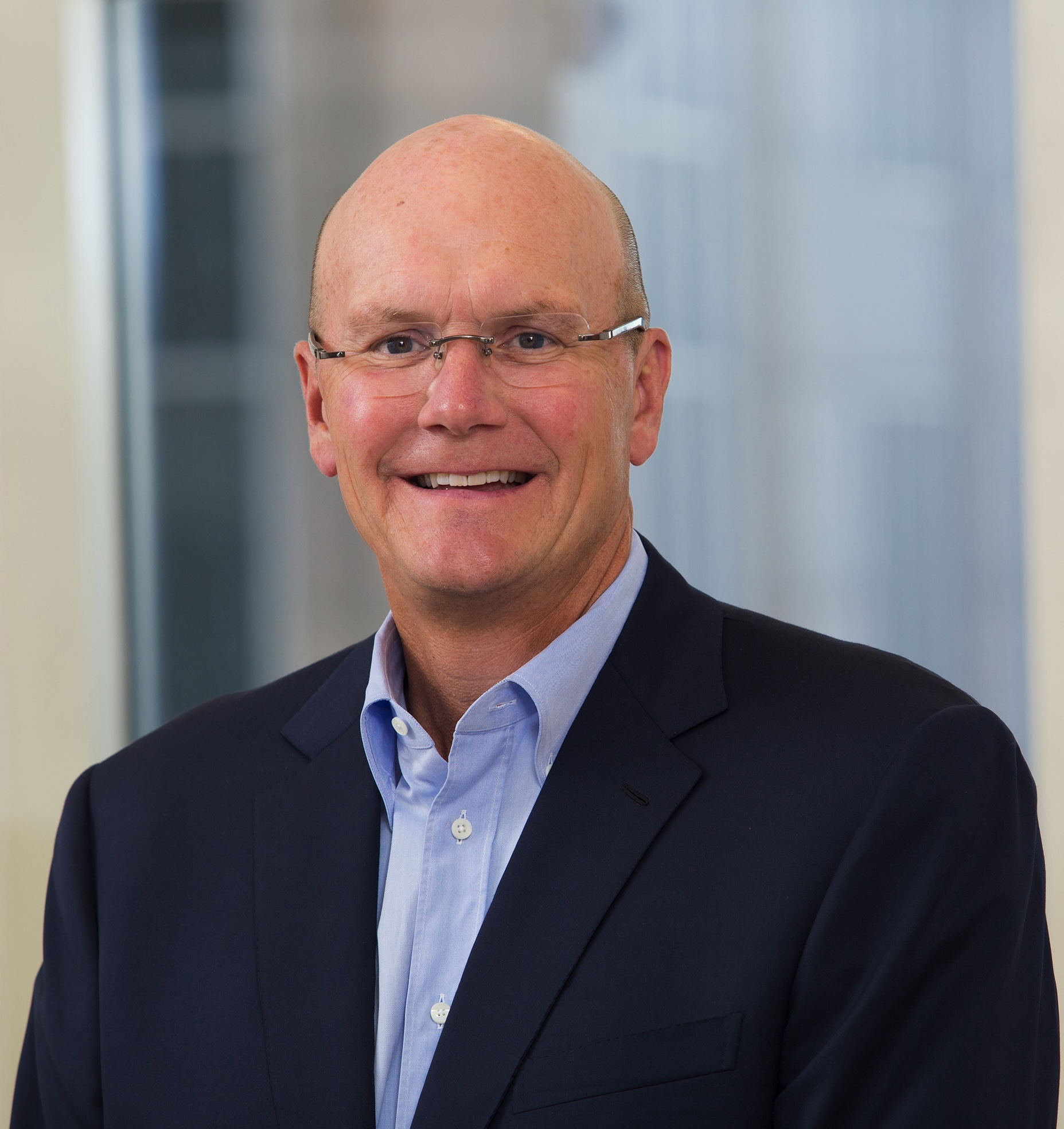 A headshot of a man wearing glasses