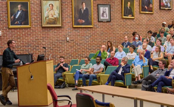 John Jumper speaks from a podium during the Apex Lecture.