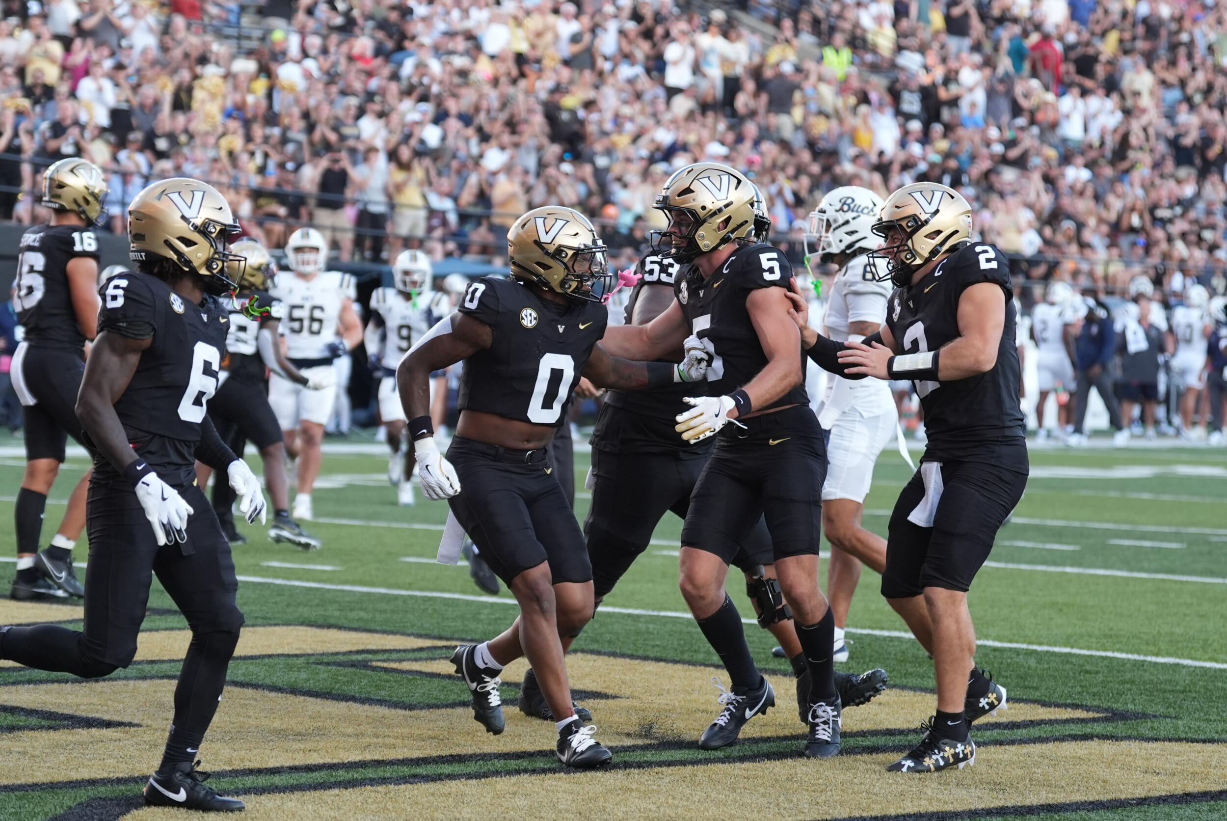 Vanderbilt football team members celebrate on field