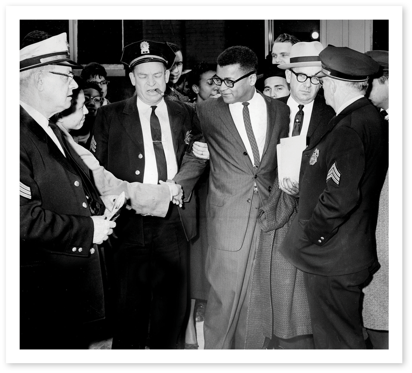 Black and white photo of Rev. James Lawson being arrested in March 1960 for protesting segregation in Nashville with police officers as well as well wishers.