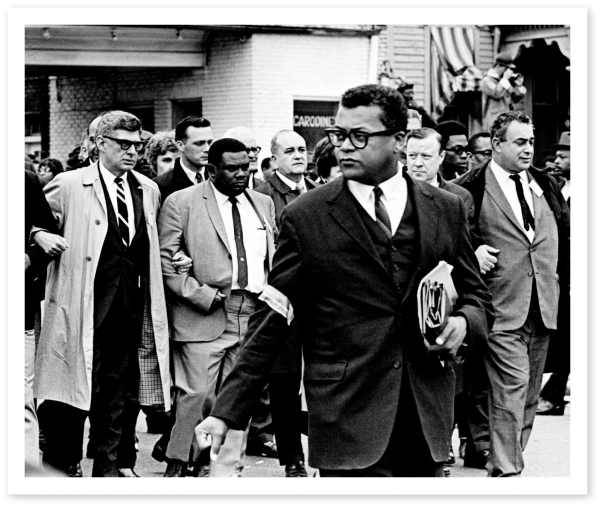 Black and white photos of Rev. Lawson with black and white men, elbows linked, marching in Memphis on April 8, 1968, to honor the late Dr. Martin Luther King Jr.