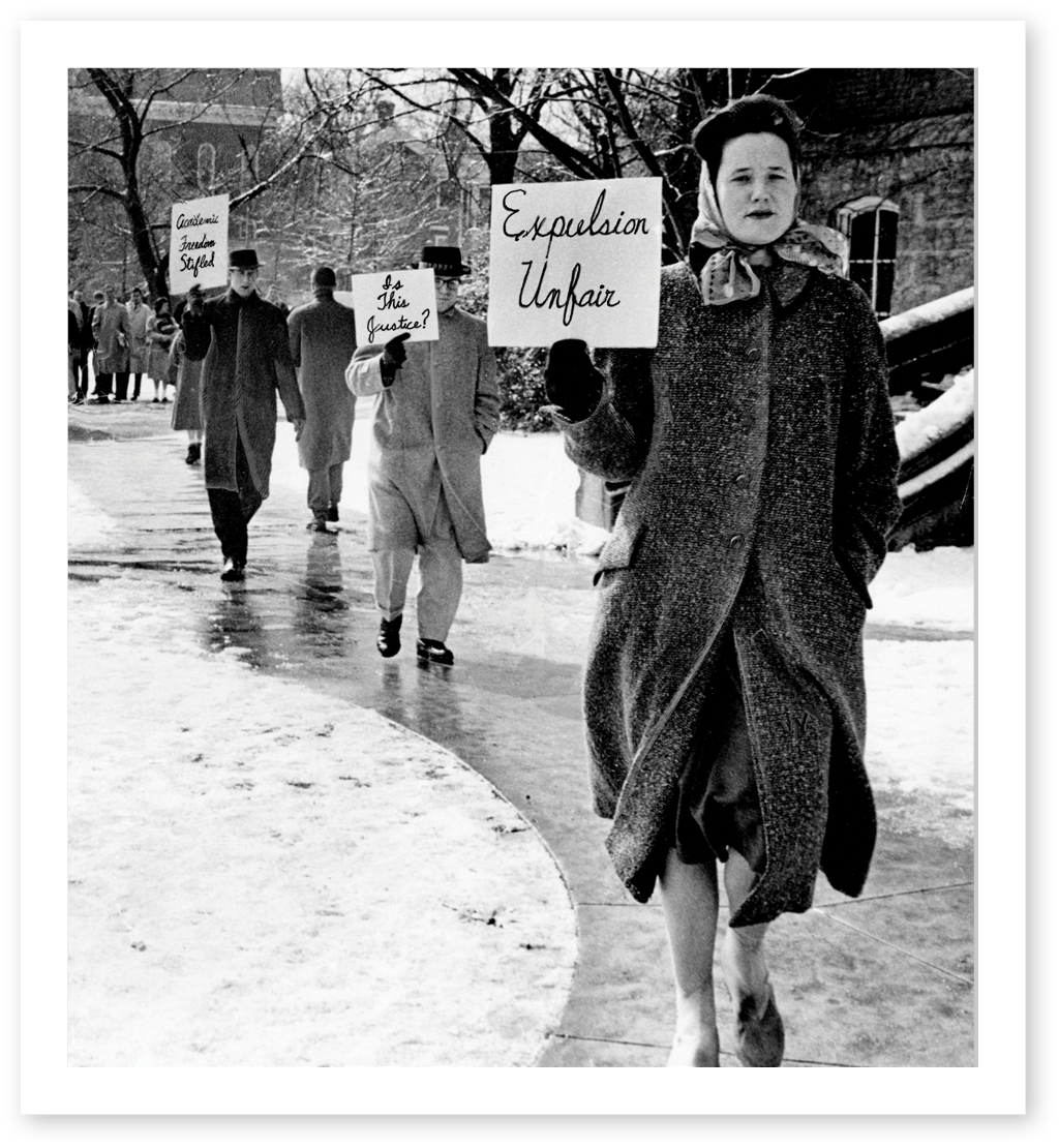 Black and white photo of divinity students protesting with handmade signs.