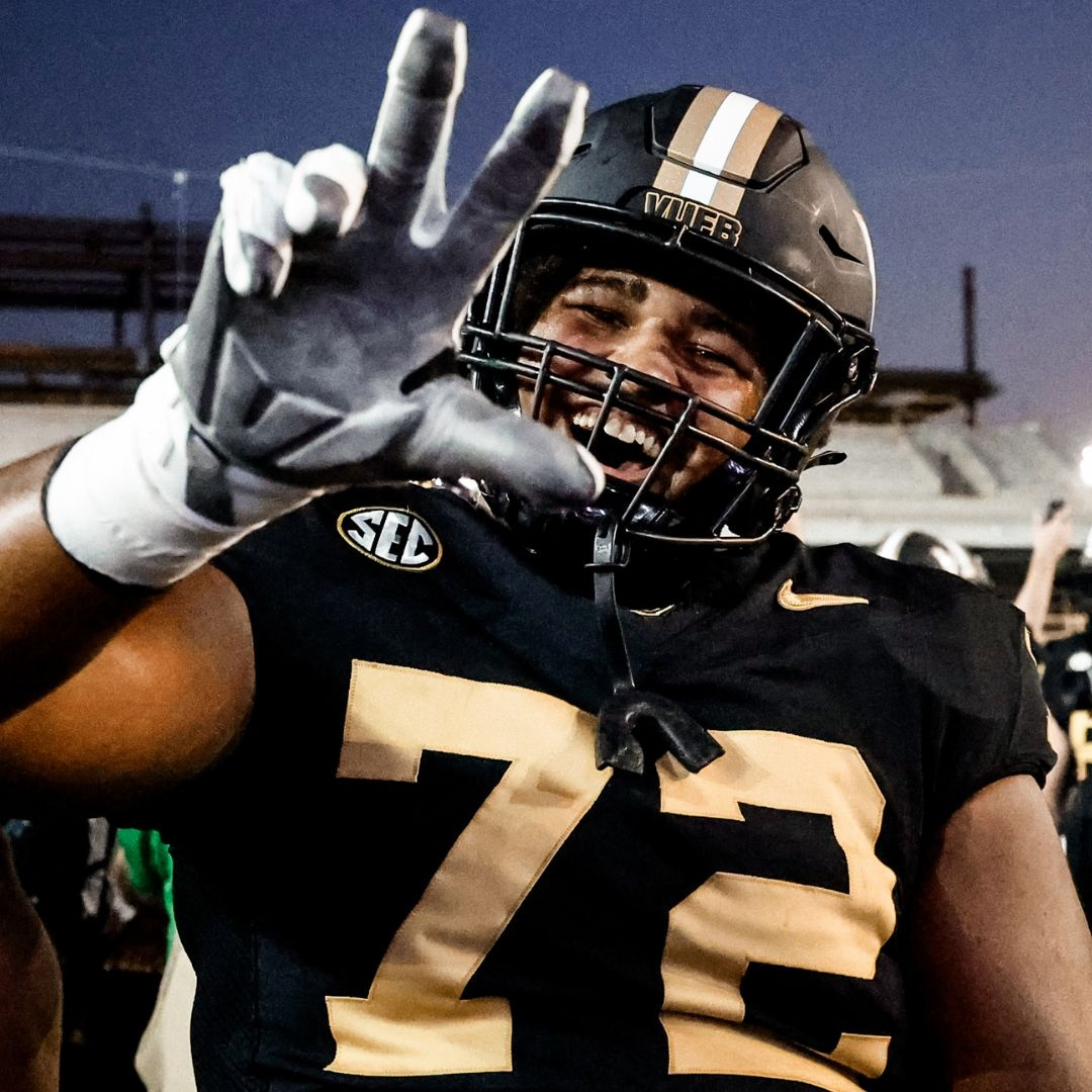 Vanderbilt football player Josh Raymond holds up the 