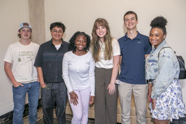 Several students smile at the exhibit opening