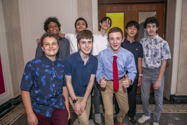 Several students smile at the exhibit opening