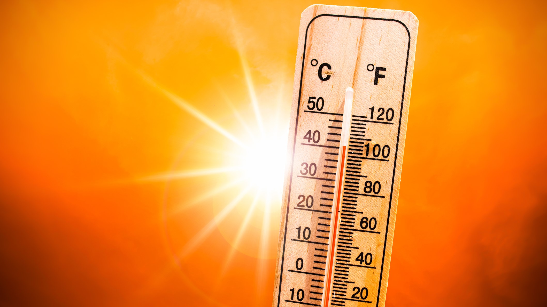 A bright sun sits behind a thermometer showing a 100+ degree fahrenheit reading.