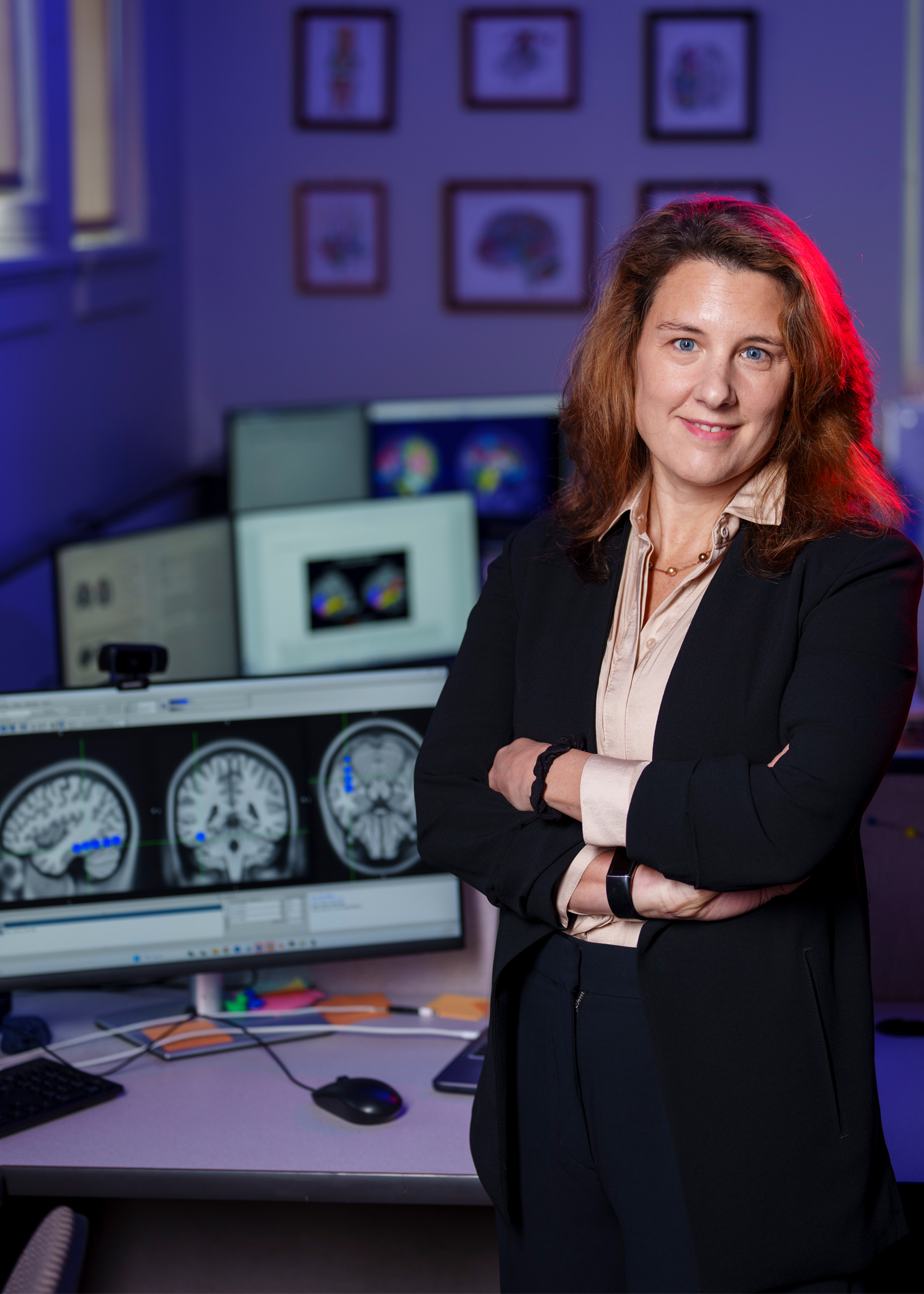 Laurie Cutting is pictured in a lab standing next to a computer monitor.