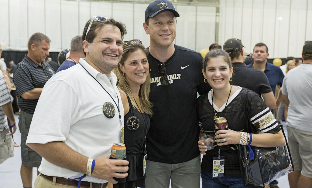 NBC and MSNBC news anchor Willie Geist, BA’97 (center) poses with fans at the tailgate.