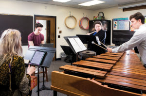 Blair student Chris Bell rehearsing his composition with chatterbird chamber ensemble musicians playing flute, marimba and singing.