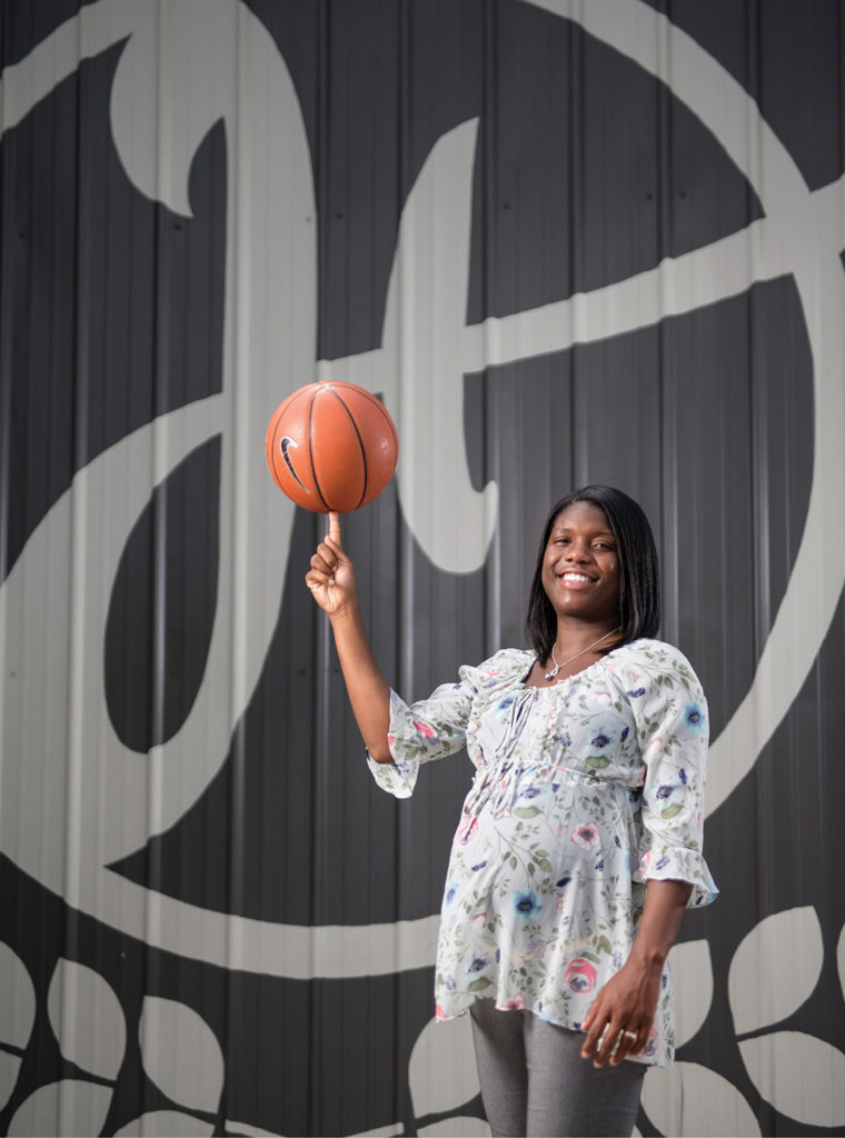 “I believe in being part of the community,” says alumna Jessica Mooney Holman, who is expecting her first child soon. “We made an intentional decision to be here.” Here she stands in front of Harvest Hands’ new 18,000-square-foot building. (JOE HOWELL)