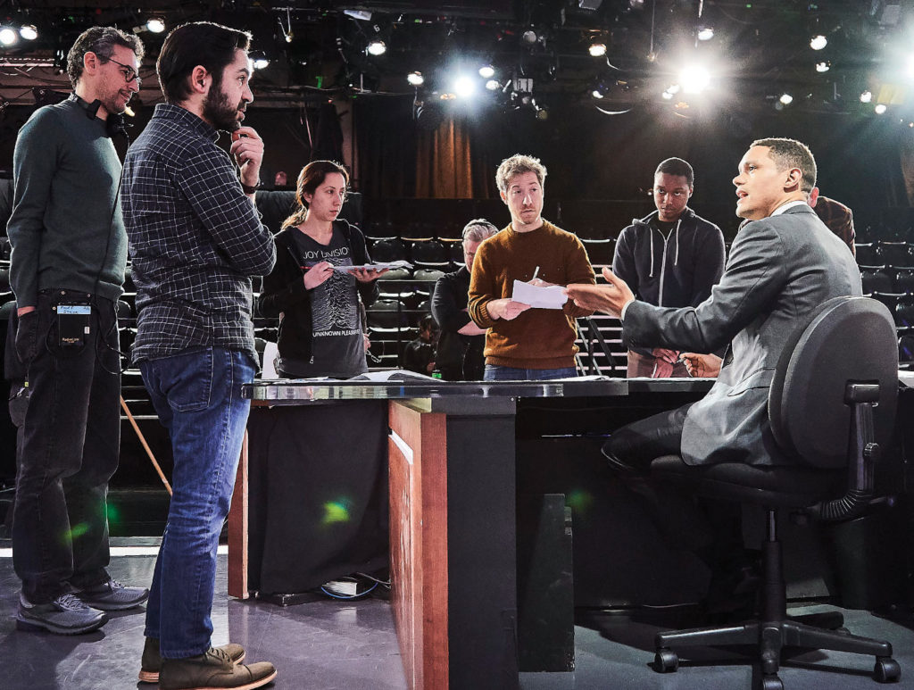 Zhubin Parang, BS’03 (foreground, left), and his writing staff discuss the day’s script with Trevor Noah (seated) on the set of The Daily Show with Trevor Noah. Photo by Sean Gallagher/The Daily Show with Trevor Noah