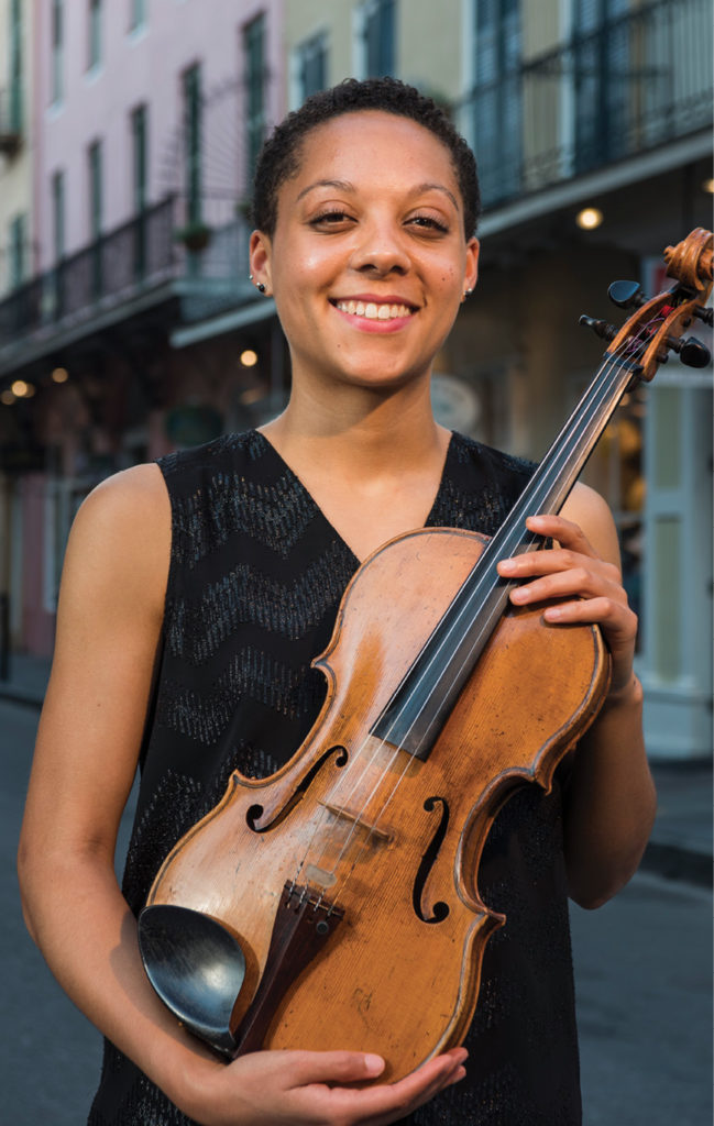 Portrait of Dana Kelley, with her viola, on a street on a city street